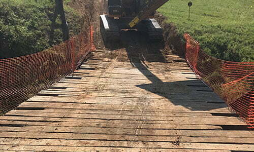 bridge kit shown spanning a creek while heavy construction equipment approaches to cross it similar image but different enough from the above that it could be used in the collage